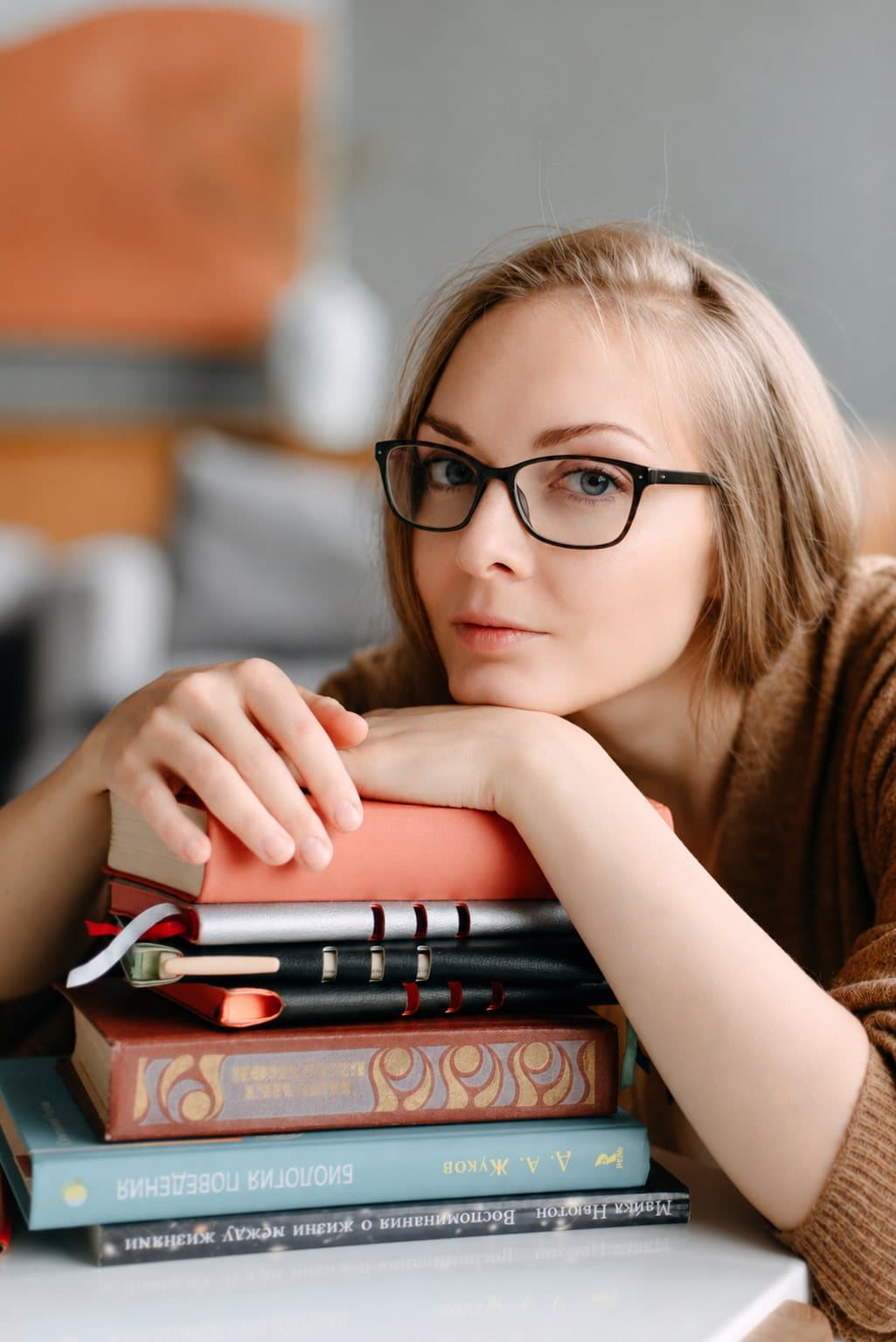 Anna Daccache resting her arms on a stack of books